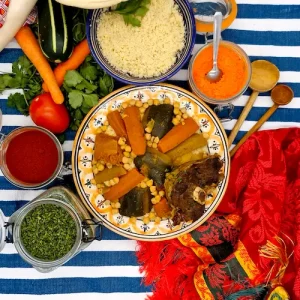 Un couscous d'agneau est disposé sur une table orientale. L'assiette est bordée d'un décor coloré et invitant au voyage gustatif.